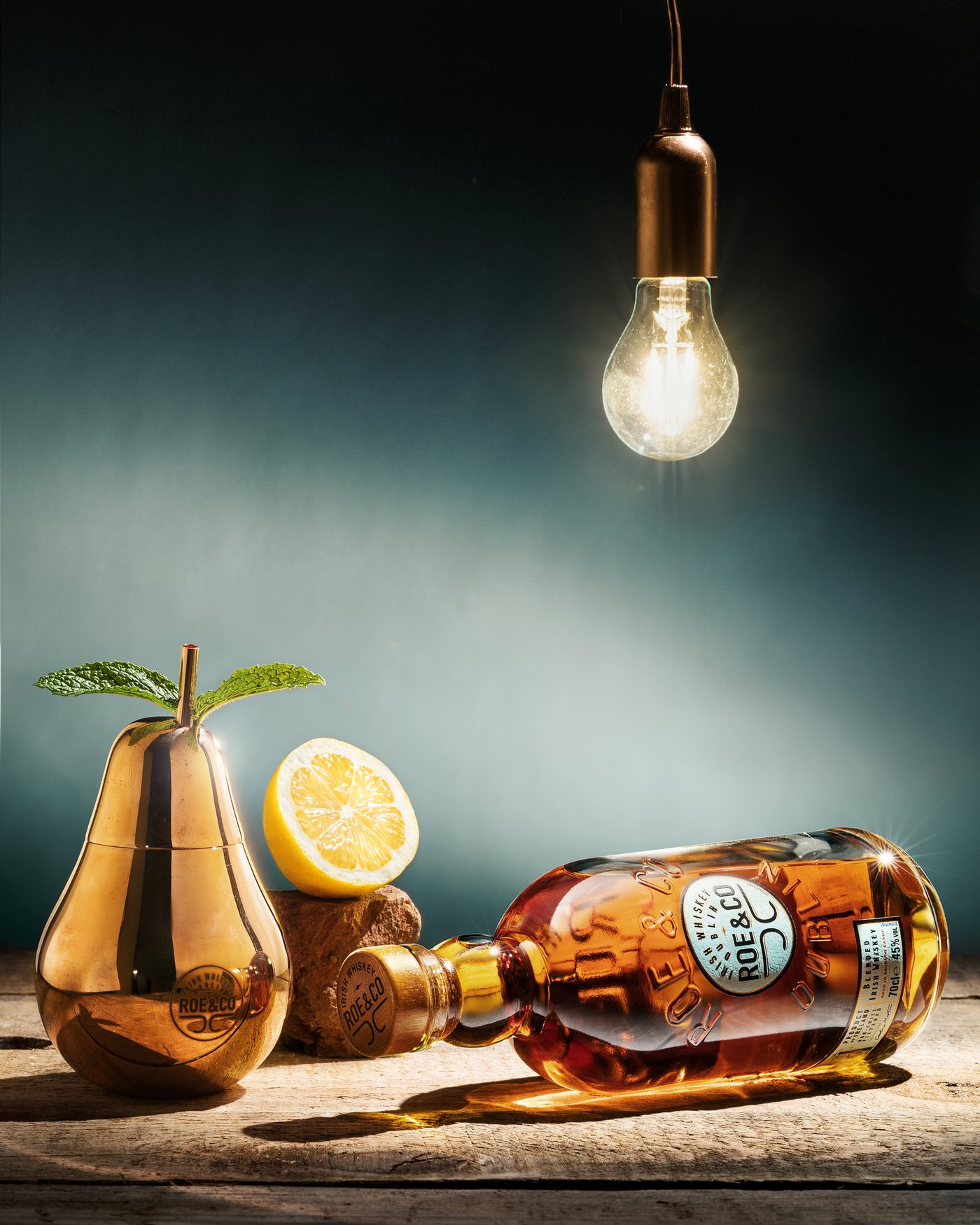Als Stilleben inszeniertes Produktfoto einer Whiskeyflasche mit Kupferbirne als Trinkgefäß
