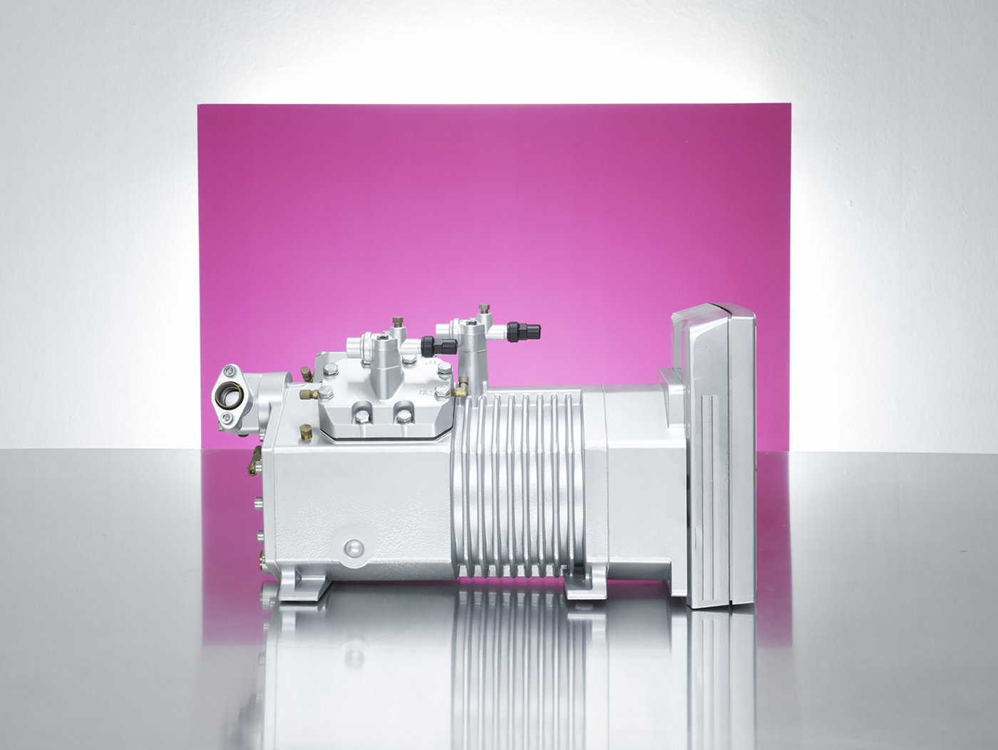 Studiofotografie eines industriellen Produkts, Motorblock vor Hintergrund magenta